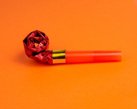 Party foil red horn noisemaker for carnival on the orange backgroundの写真素材