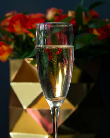 One champagne glass selective focus with rose on dark backgroundの写真素材