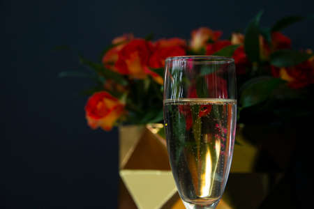 One champagne glass selective focus with rose on dark backgroundの写真素材