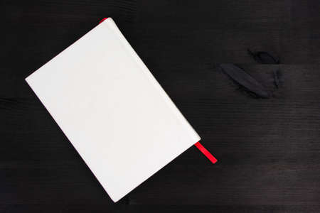 White book with copy space on dark wooden backgroundの写真素材