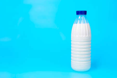 Natural fresh milk bottle on blue background with copy space