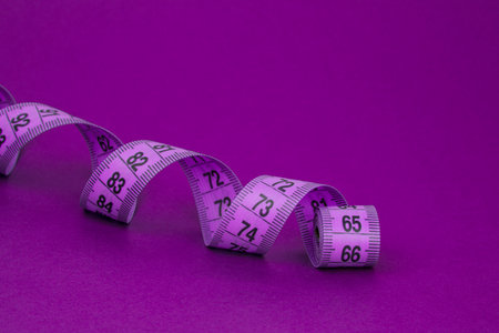 Colorful violet tape measure spiral with copyspace background