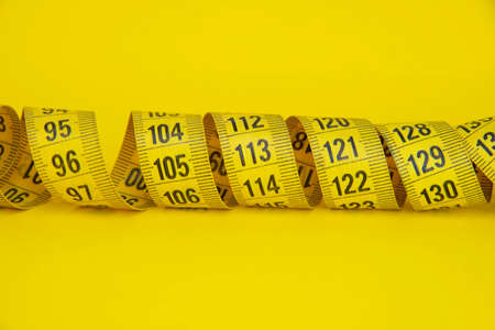 Yellow tape measure diet concept on background with copyspaceの写真素材