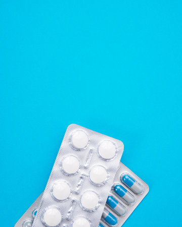 Pills in blister on blue background with space for text