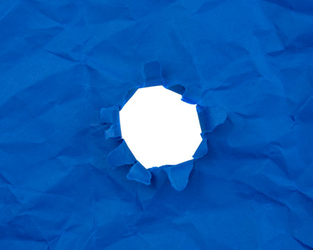 Paper hole with torn sides on a background. Through the paper. A ragged hole.An accurate shot. The concept of advertising and breakthrough.の写真素材