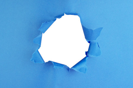 Hole in paper color background damaged rippedの写真素材