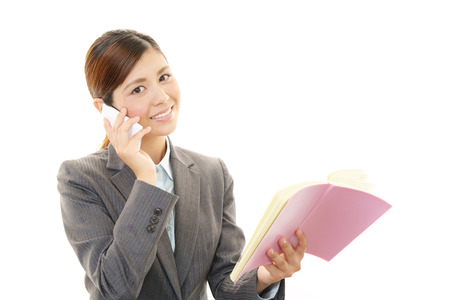 The female office worker who uses the cellphone の写真素材