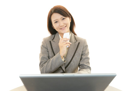 The female office worker who uses the smart phoneの写真素材
