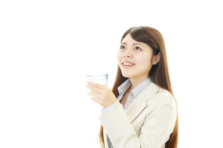 A young woman drinking a glass of waterの写真素材