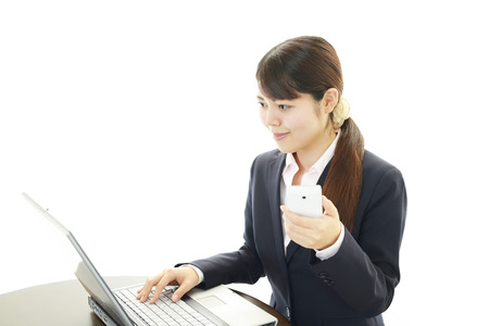 The female office worker who uses the smart phone の写真素材