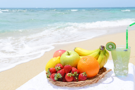 beautiful beach and fresh fruitsの写真素材