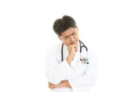 Portrait of an overworked and tired Asian doctorの写真素材