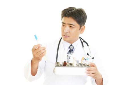 Portrait of an overworked and tired Asian doctorの写真素材