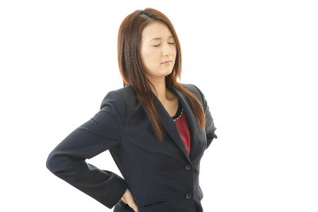 Business woman with back painの写真素材
