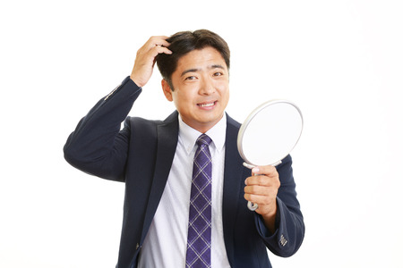 Man combing his hairの写真素材