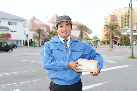 Smiling delivery man isolated on white 