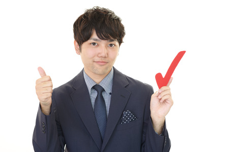 Smiling Asian businessman with check markの写真素材