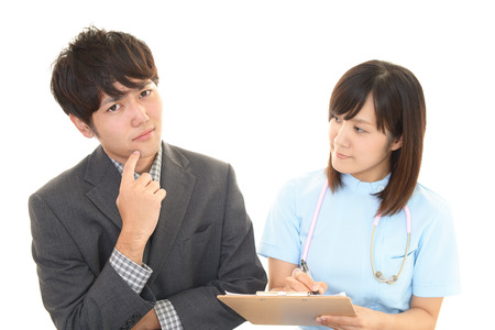 Smiling female nurse taking a health interviewの写真素材