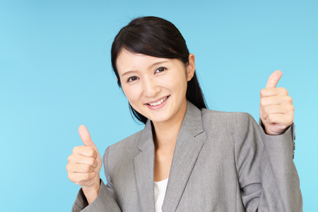Smiling business woman with thumbs upの写真素材