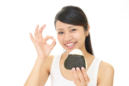 Woman eating rice ballの写真素材