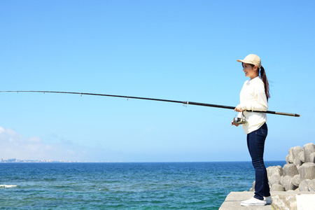 Woman fishing at seaの写真素材