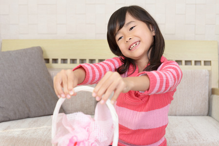 Joyful girl holding a gift in her handsの写真素材