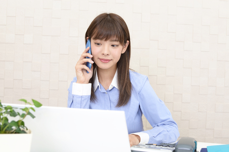 Business woman who is talking on a smart phoneの写真素材