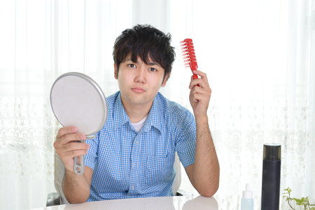 A man taking care of his hairの写真素材