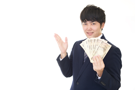 Smiling Asian businessman with moneyの写真素材