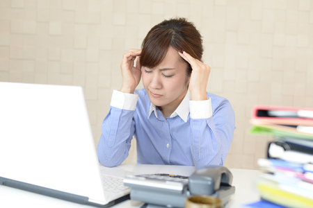 Tired and stressed Asian business womanの写真素材