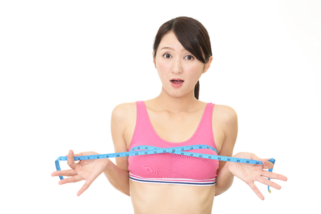 Young woman measuring her breastの写真素材