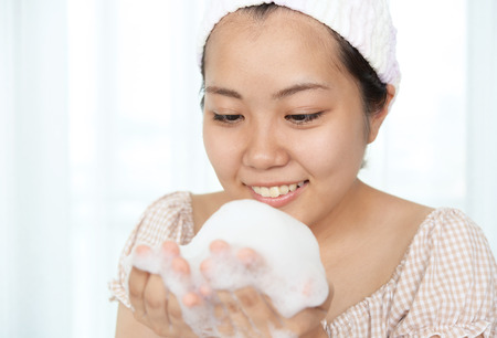 Young woman washing her faceの写真素材