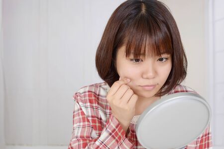 Young upset woman has problems with her skinの写真素材