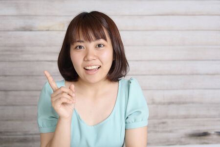 Asian young woman pointing with her fingerの写真素材
