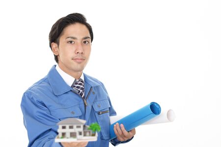 Smiling Asian worker with a housing modelの写真素材