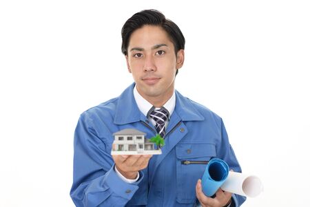 Smiling Asian worker with a housing modelの写真素材