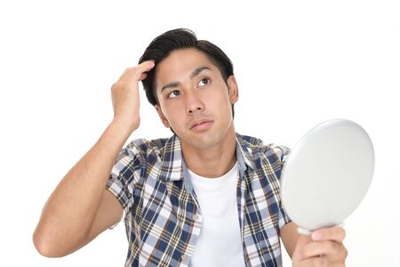 Man looking unhappy with his hairの写真素材