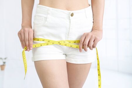 Woman measuring her bottomの写真素材