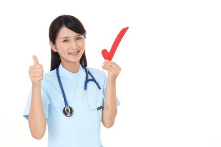 Smiling female nurse with a check markの写真素材