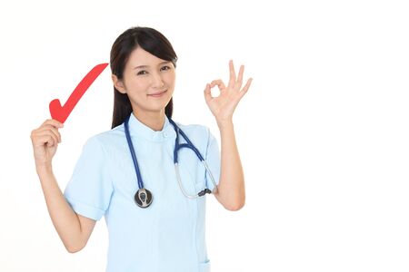 Smiling female nurse with a check markの写真素材
