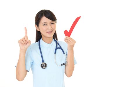 Smiling female nurse with a check markの写真素材