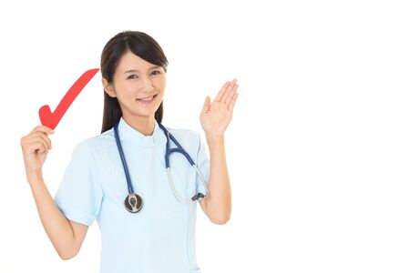 Smiling female nurse with a check markの写真素材