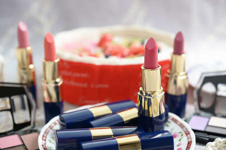 Decorative cosmetics and cake on the table.の写真素材