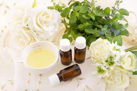 Bottles of essential oil and flowers.の写真素材