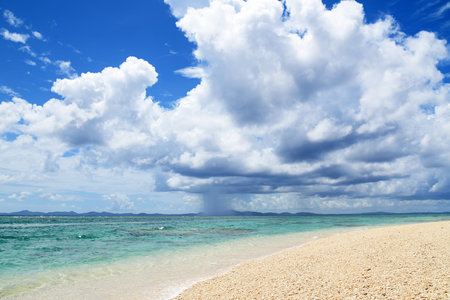 Beautiful beach and tropical sea under the blue sky with white cloudsの写真素材