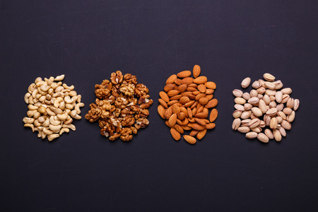 Assortment of nuts on a black background - healthy snack. Top view. Copy spaceの写真素材