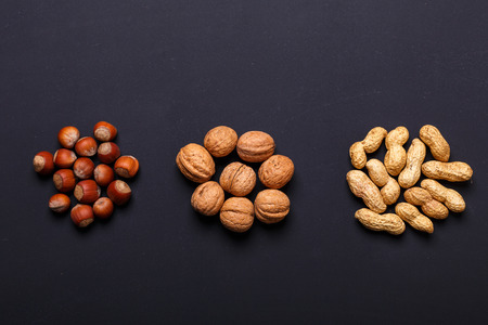 Assortment of nuts on a black background - healthy snack. Top view. Copy space