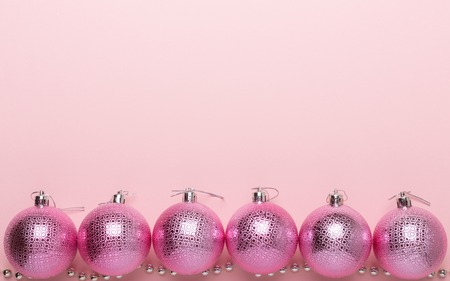 Pink christmas balls on a paper background. Top view, flat lay, copy spaceの写真素材