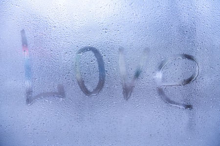 The word Love , rain or water drops on window glasses. Abstract background.の写真素材