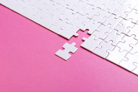 White puzzle on pink background. Missing piece. Top viewの写真素材
